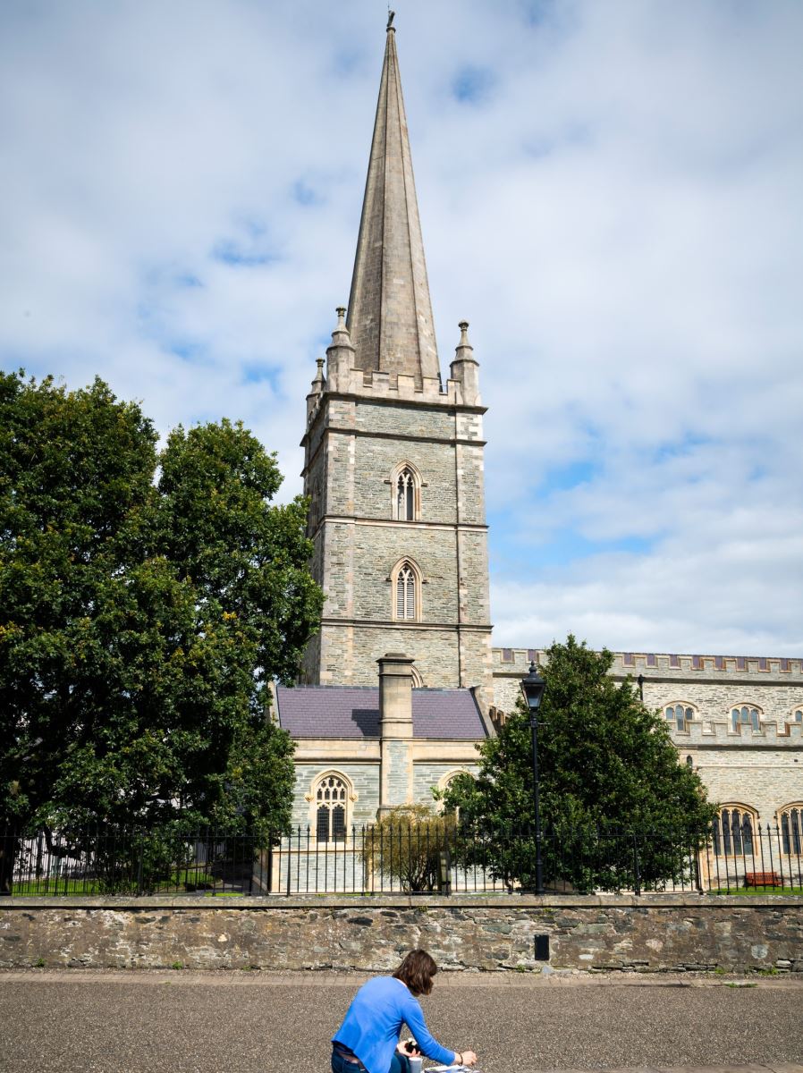 Person sitting outside St Columbs Cathedral